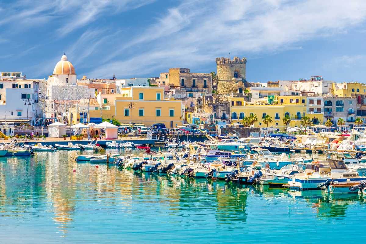 Tramonto su Ischia con il mare calmo e le montagne sullo sfondo