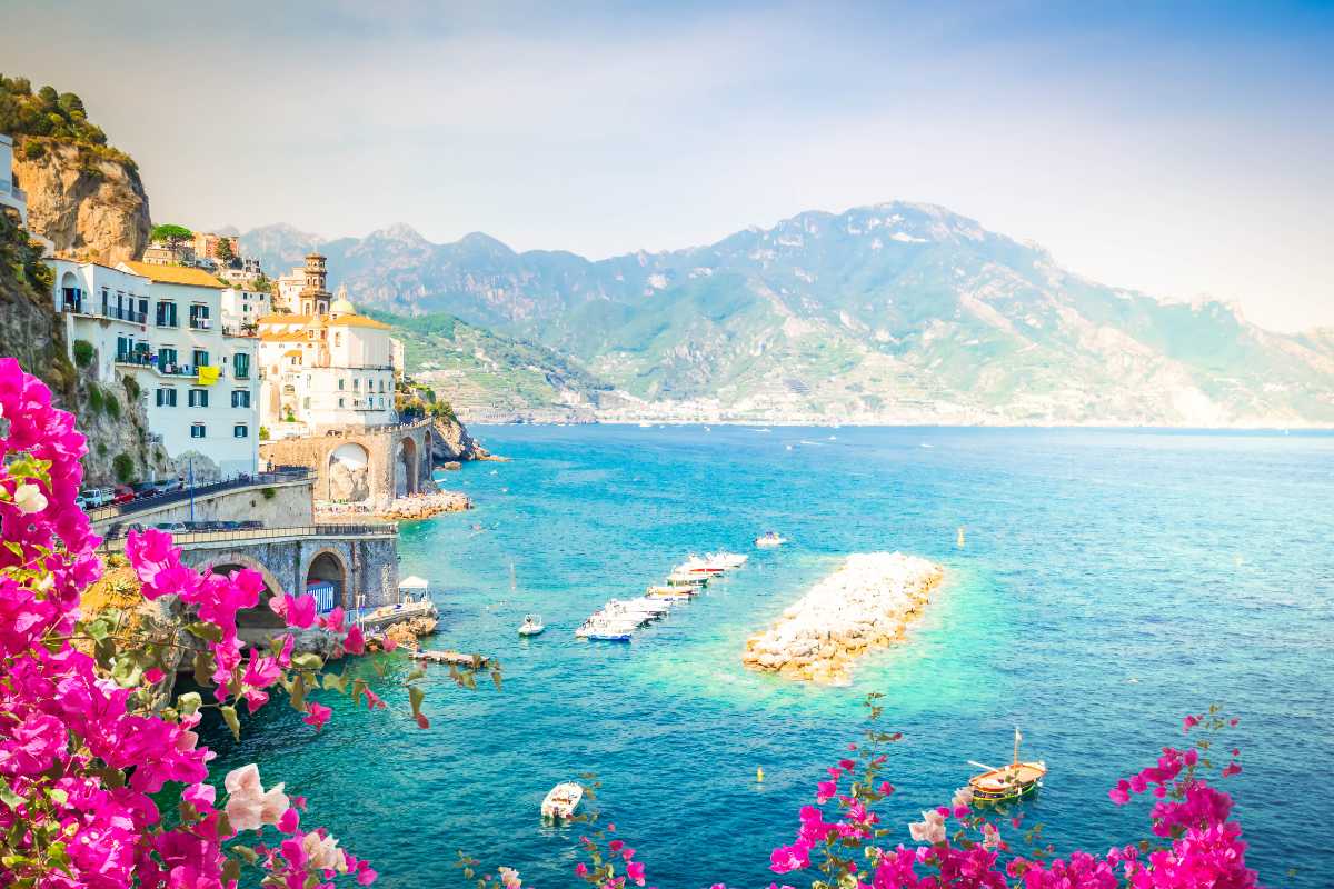 Vista panoramica della Costiera Amalfitana con piatti tipici in primo piano