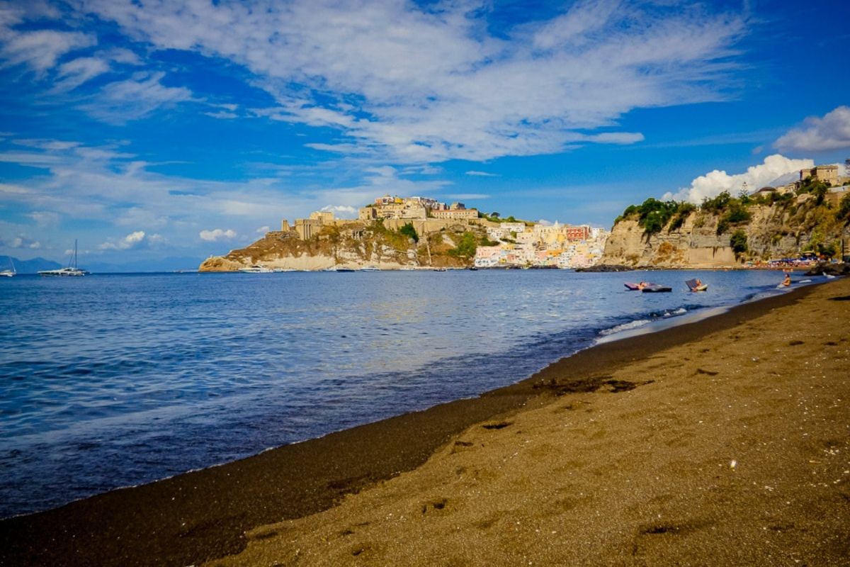 Spiaggia di Procida con case colorate sullo sfondo