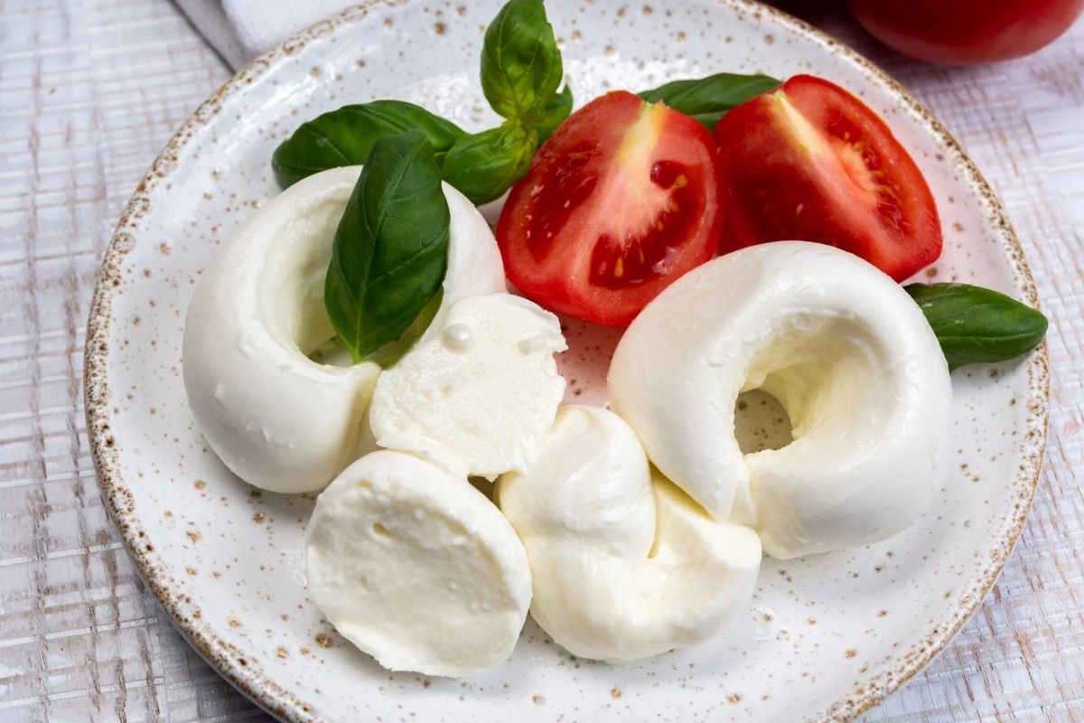 Dettaglio di un piatto di mozzarella di bufala DOP, evidenziando la freschezza e la cremosità del prodotto.